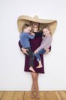 Женщина в сомбреро, защищающая себя и двоих детей — стоковое фото
