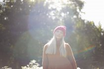 Retrato de mulher na floresta usando chapéu de malha olhando para a câmera — Fotografia de Stock