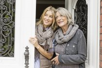 Mother and daughter by front door — Stock Photo