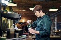 Caucasian male barista making coffee — Stock Photo