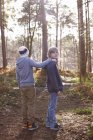 Twin brothers standing together in woods — Stock Photo