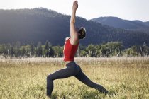Mujer joven haciendo ejercicio en el campo, Missoula, Montana, EE.UU. - foto de stock
