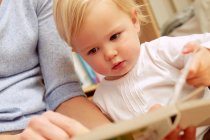 Mother reading picture book with baby daughter — Stock Photo