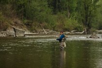 Человек рыбачит в реке — стоковое фото