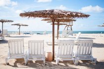 Sedie da giardino e ombrellone in spiaggia — Foto stock