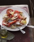 Высокий угол обзора салата с помидорами и хлебом на тарелке — стоковое фото