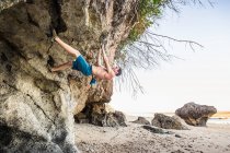 Maschio arrampicatore free climbing strapiombo sulla spiaggia di Pandawa, Bali, Indonesia — Foto stock
