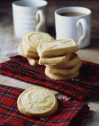 Escocês todos biscoitos manteiga shortbread empilhados na toalha de chá tartan — Fotografia de Stock