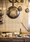 Металевий посуд, що висить на комерційній кухні — стокове фото
