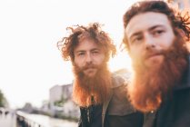 Jeunes jumeaux hipster mâles aux cheveux roux et barbe sur le front de mer du canal — Photo de stock