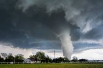Storm cloud and tornado in countryside — Stock Photo