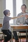 Father holding paper plane for son indoors — Stock Photo