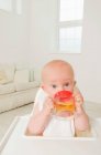 Um retrato de um bebê bebendo suco . — Fotografia de Stock