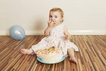 Menina da criança devorando bolo de aniversário — Fotografia de Stock