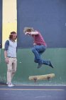 Молодий дорослий чоловік робить трюк для скейтбордингу на міській вулиці — стокове фото