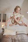 Girl floating above bed — Stock Photo
