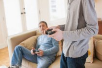 Отец и сын играют в видеоигры в гостиной — стоковое фото