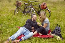 Pareja romántica sentada de picnic en el campo rural - foto de stock