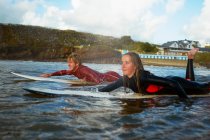 Dos surfistas remando en tablas de surf - foto de stock