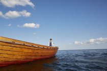 Мальчик-подросток на лодке смотрит вдаль в голубой океан — стоковое фото