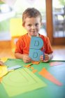 Portrait of boy with letter B at nursery school — Stock Photo