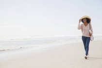 Молода жінка, що йде на пляжі — стокове фото