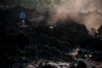 Uomo che corre su una spiaggia rocciosa — Foto stock