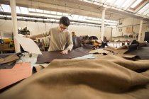 Man working in leather jacket manufacturers — Stock Photo