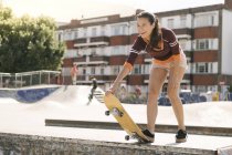 Skateboarderin bereitet sich auf Skateboard-Rampe vor — Stockfoto