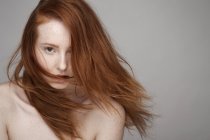 Porträt einer jungen Frau mit windgepeitschten Haaren — Stockfoto