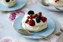 Cream meringue with berries and spoon on plate — Stock Photo
