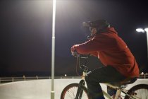 BMX-ciclista a caballo por la noche - foto de stock
