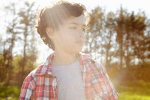 Retrato de menino vestindo camiseta verificada no parque — Fotografia de Stock