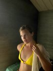 Porträt einer jungen Frau, die Bluse über Bikini-Oberteil anzieht — Stockfoto