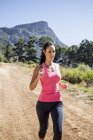 Young woman jogging in forest — Stock Photo