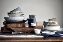 Stacked crockery stacked on cutting board for washing up — Stock Photo