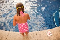 Молода дівчина стоїть біля басейну, високий кут — стокове фото