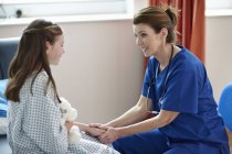 Медсестра разговаривает с пациенткой начального возраста в клинике — стоковое фото