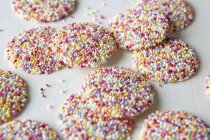Primo piano di caramelle nonpareil su superficie bianca — Foto stock