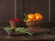 Clementines with cranberries and rosemary — Stock Photo