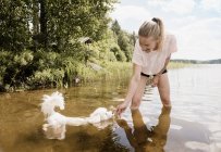 Frau mit coton de tulear Hund im See, orivesi, Finnland — Stockfoto