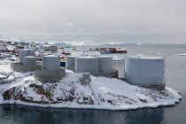 Vista elevada de los tanques de petróleo cubiertos de nieve en Ilulissat, Groenlandia - foto de stock