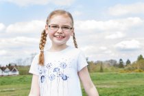 Portrait of redhead girl in spectacles with plaits — Stock Photo