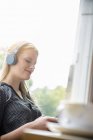 Mujer joven escuchando música con auriculares - foto de stock