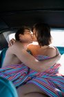 Чоловік і жінка на задньому сидінні автомобіля цілуються — стокове фото