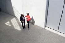 Бізнес-леді спілкуються в коридорі сучасної офісної будівлі — стокове фото