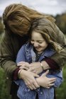 Mutter und Tochter umarmen sich auf Wiese — Stockfoto