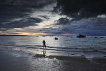 Nadador caminando por la costa, Tenby, Gales, Reino Unido - foto de stock