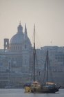Barco de pesca pela igreja carmelita e Catedral de São Paulo, Valletta, Malta — Fotografia de Stock