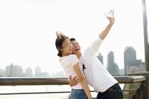 Tourist couple taking smartphone selfie, The Bund, Shanghai, China — Stock Photo